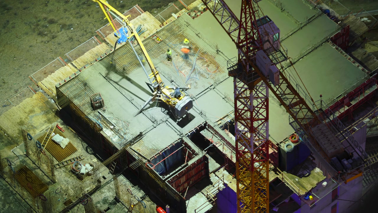 Construction Workers Pouring Concrete on High-Rise Building Site