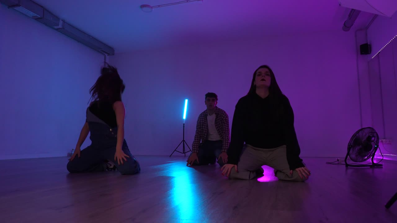 Group of Dancers Performing in Neon Lit Studio
