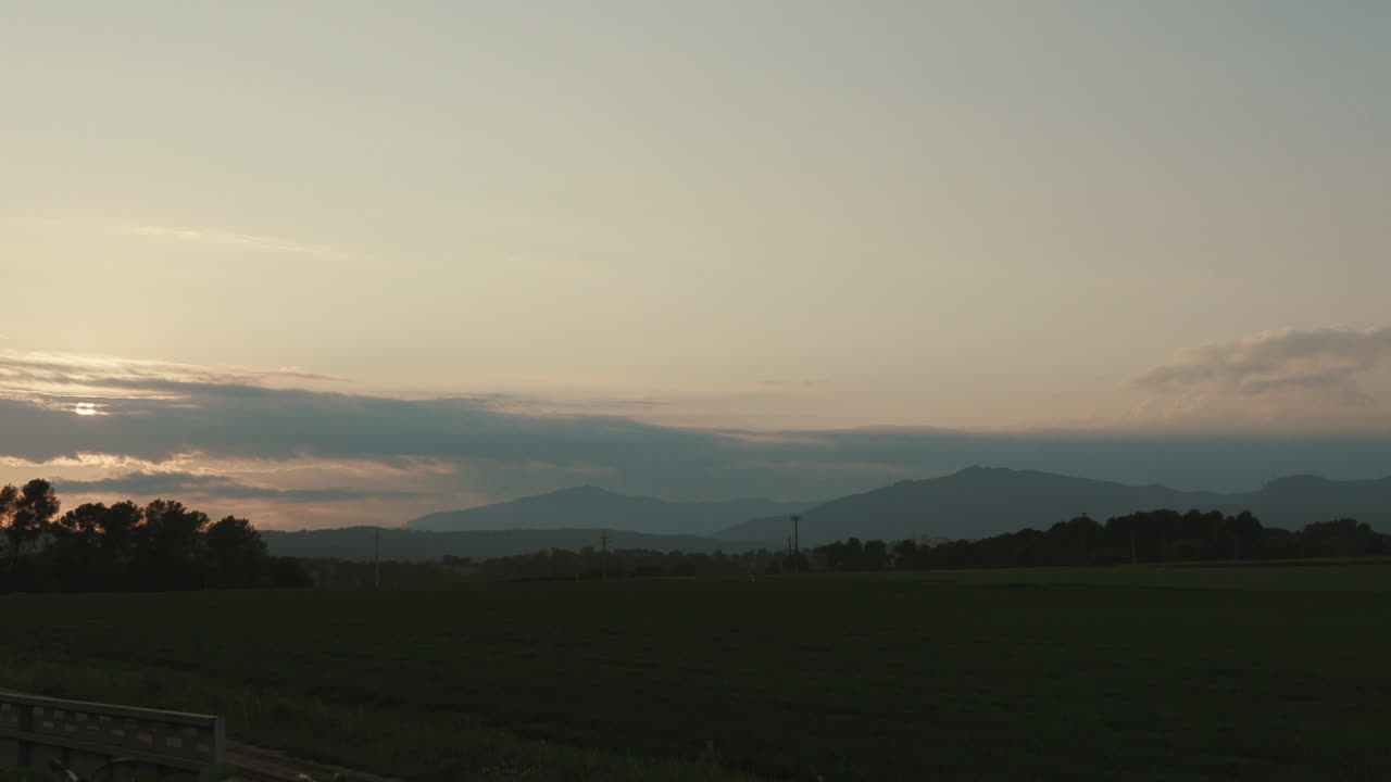4K Timelapse of the smooth movement of the clouds at sunset goldenhour in a small town