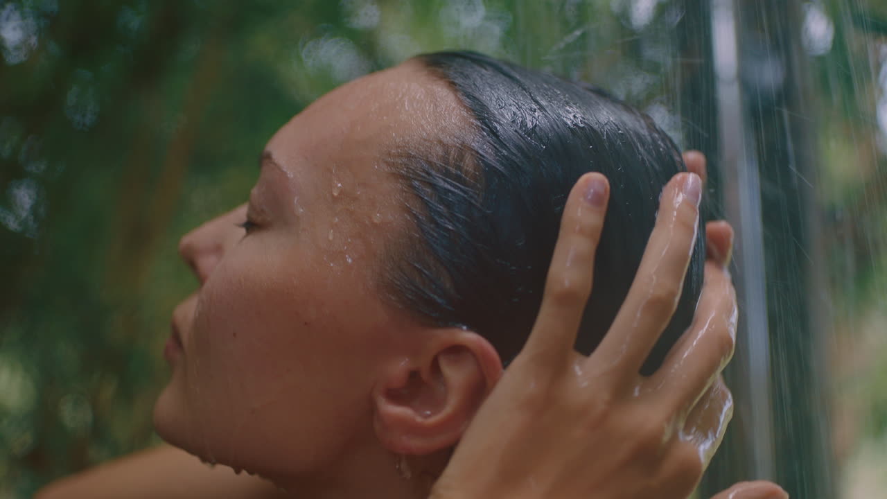 비키니를 입고 샤워하는 매력적인 여성 몸을  ⁇ 고 신선한 물로 피부를 청소하고 자연의 아름다움을 즐기고 자연에서 야외에서 샤워하는 스파