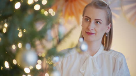 close-up of woman's hands putting christmas bauble on