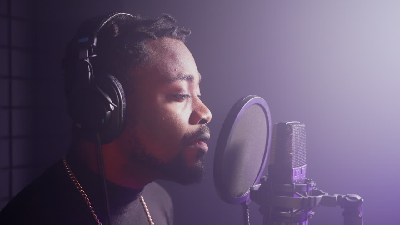 hombre cantando en un micrófono en un estudio de grabación