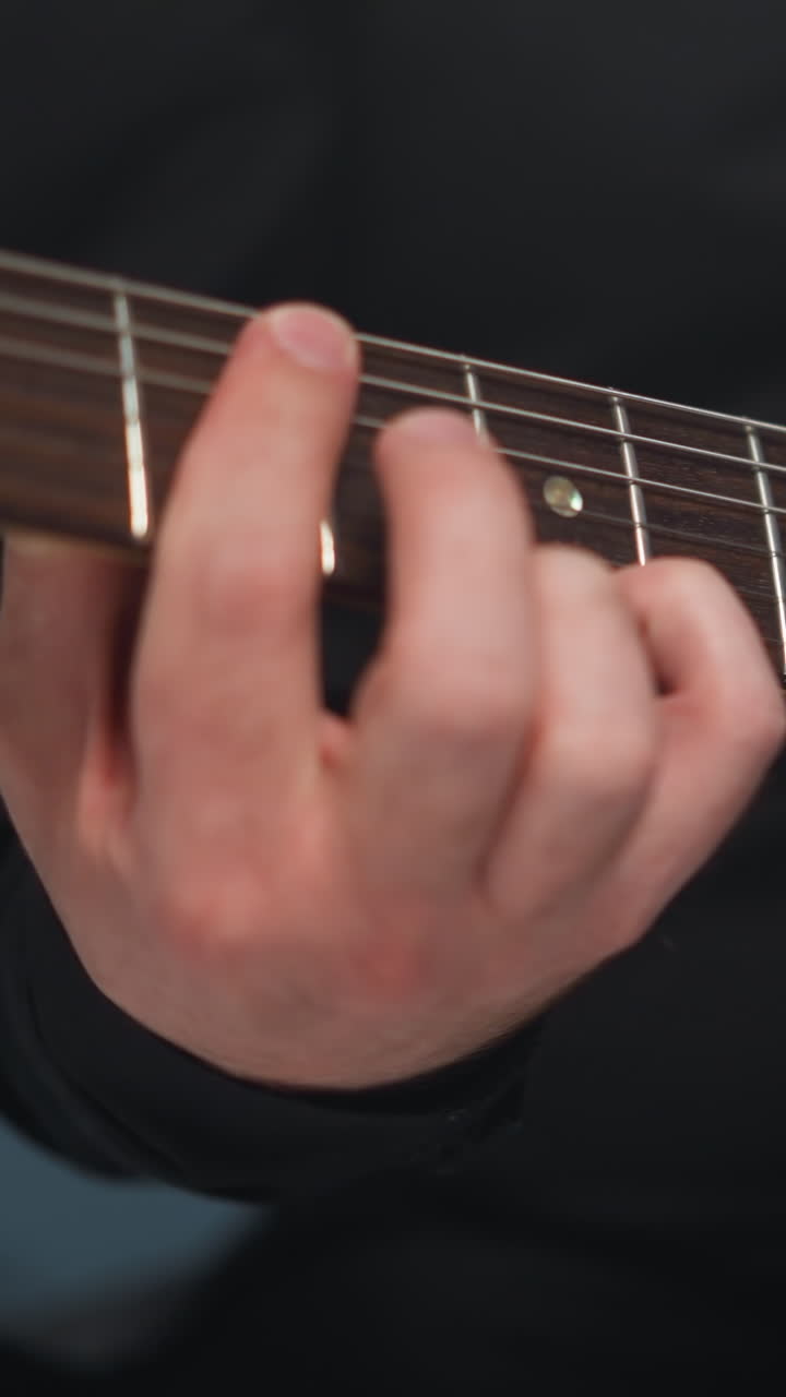 푸른 배경에 빨간 기타를 연주하는 기타리스트의 손의 가까운 시각, 악기의 복잡한 세부 사항과 음악가의 능숙한 손가락을 강조합니다.