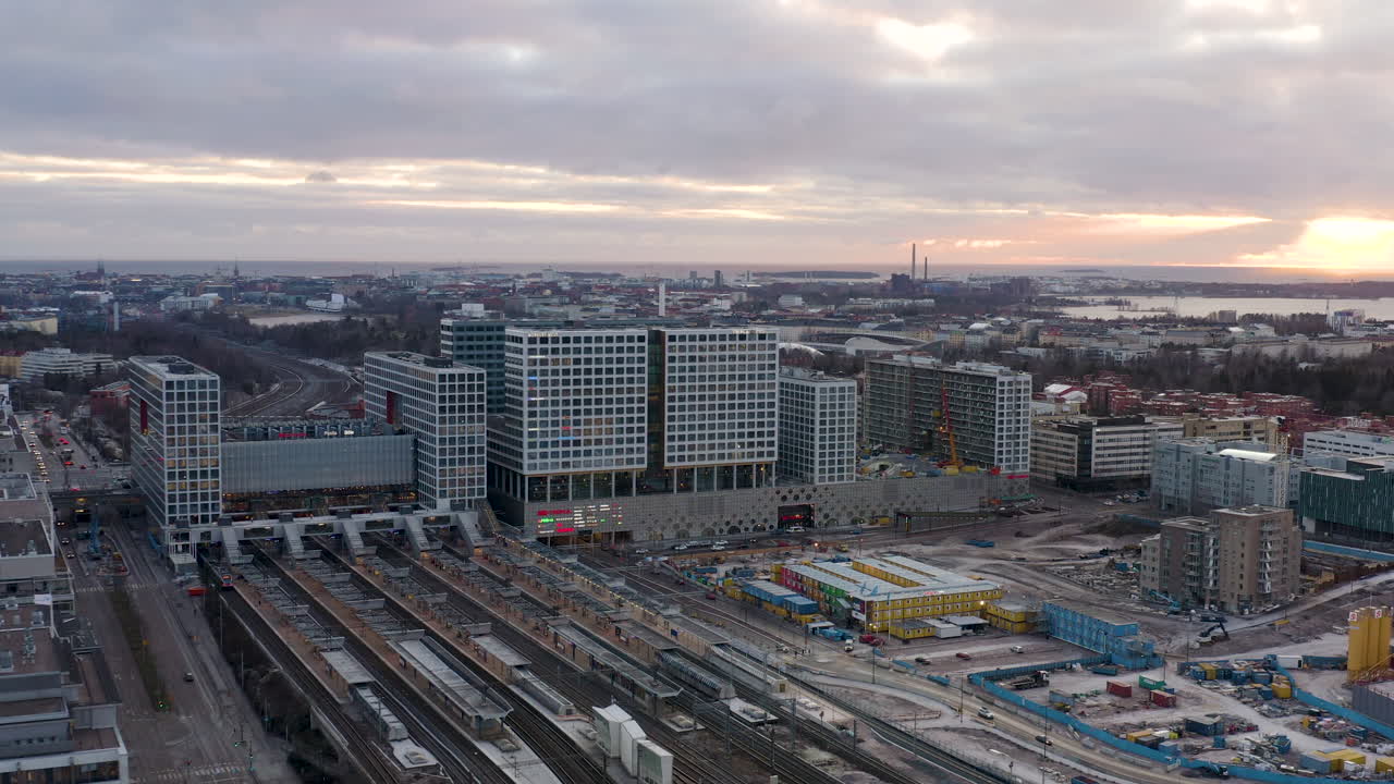 Aerial, drone shot towards the Mall of Tripla shopping center and the Pasila railway station, on a partly sunny evening, in Helsinki, Finland