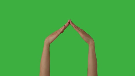 manos haciendo el marco de la casa gesto sobre la pantalla verde