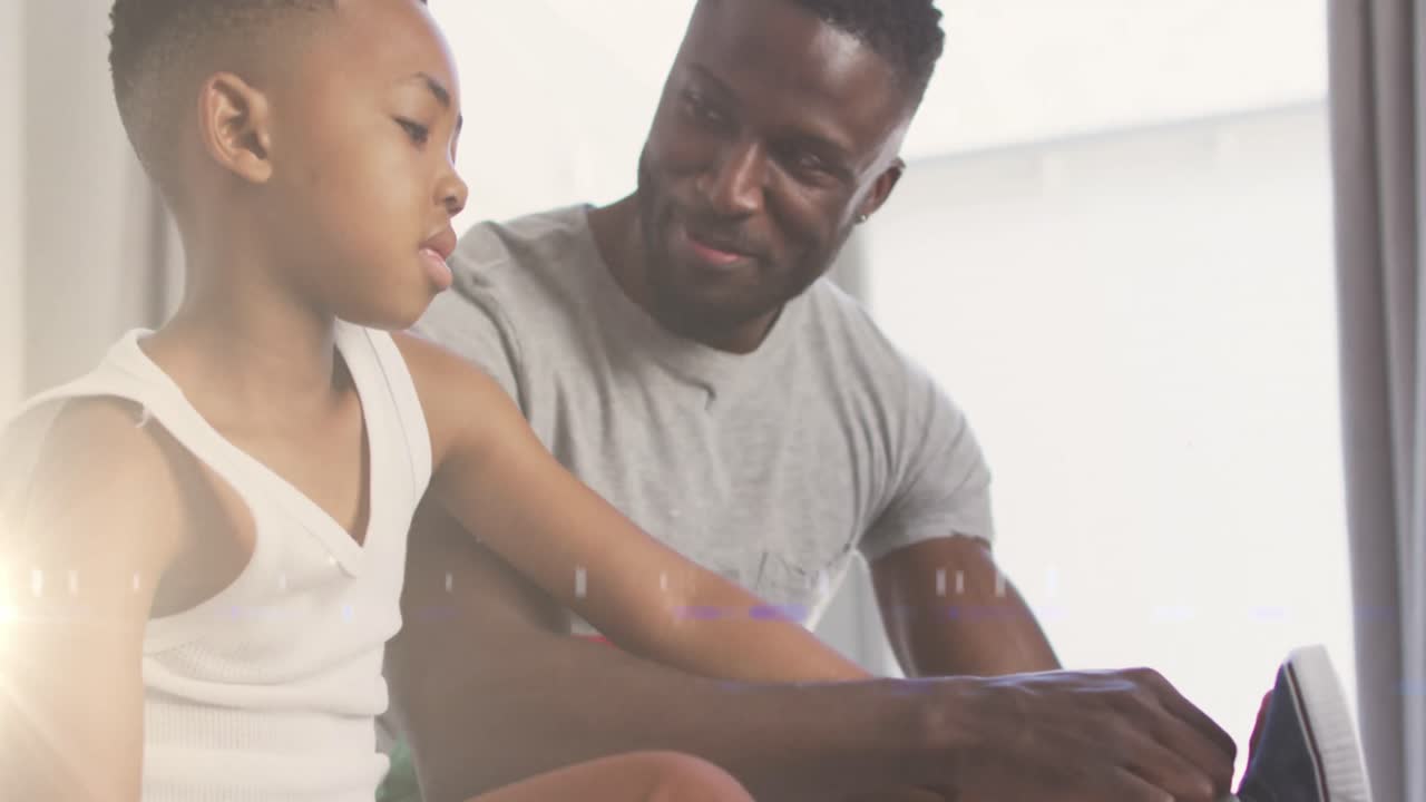 Animation of lights over happy african american father helping son to tie shoe