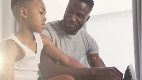 Animation-of-lights-over-happy-african-american-father-helping-son-to-tie-shoe