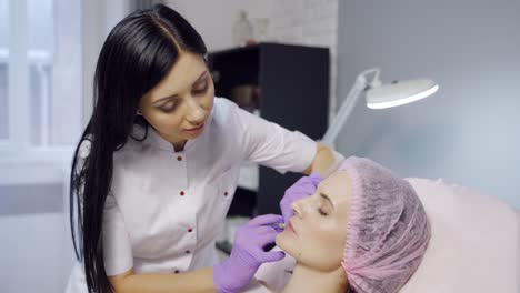 beautiful young woman gets injection in lips. beauty injections and cosmetology. plastic and aesthetic surgery.