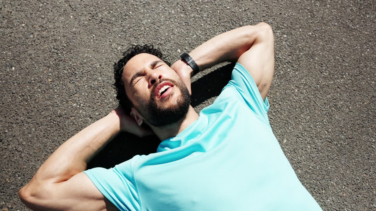 Uomo Stanco che Riposa sull'Asfalto Dopo l'Allenamento