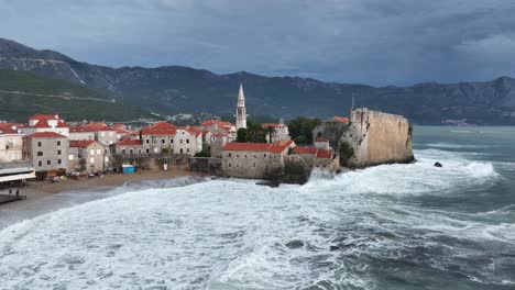aerial: budva cityscape, old town and adriatic sea during the day in montenegro, low orbit drone shot