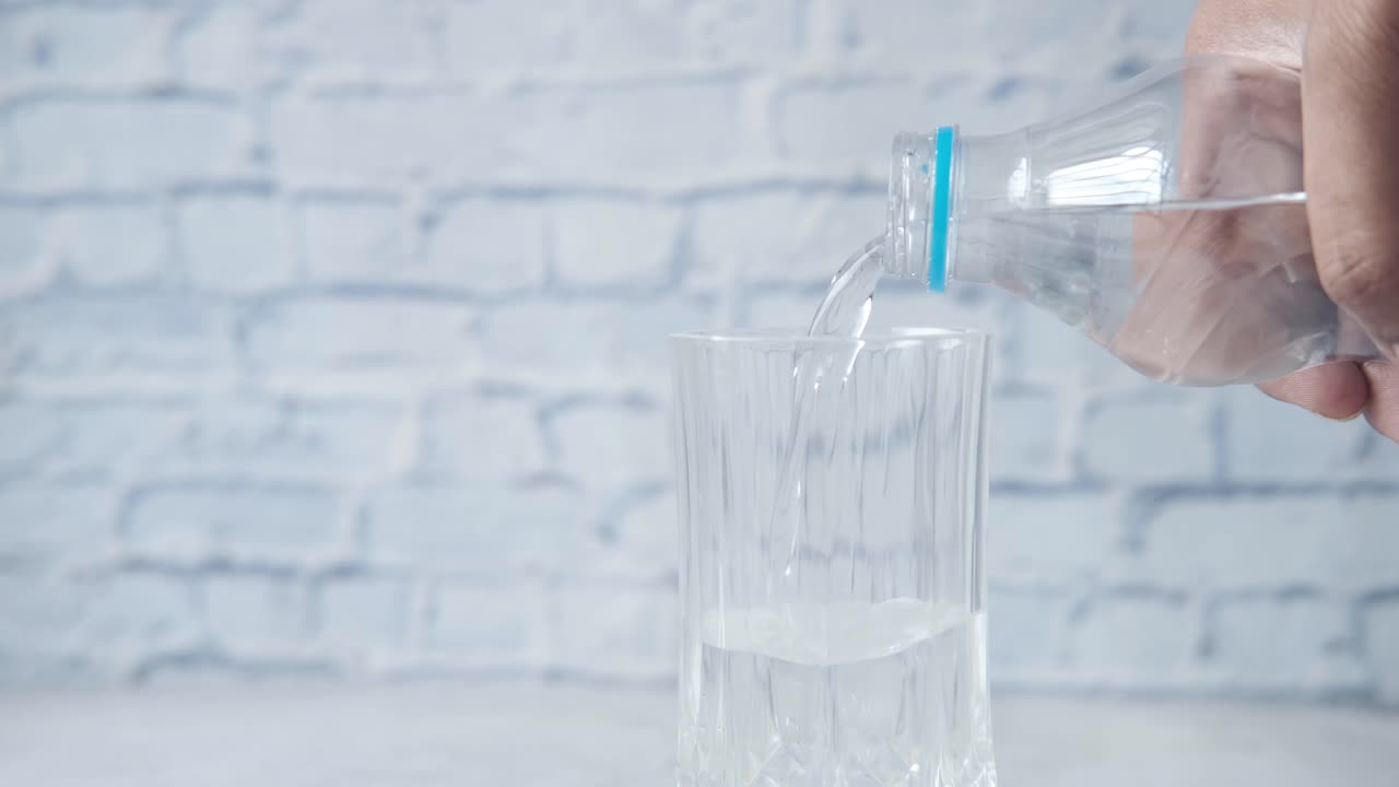 병에서 물을 유리잔에 부어 넣는 것