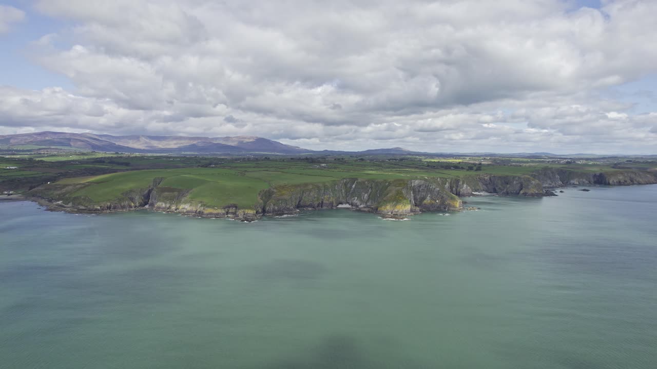lenta panorámica a la izquierda de la costa de cobre de waterford con la imponente cordillera de comeragh en el fondo en un brillante día de primavera irlanda en su mejor momento