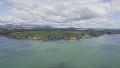 slow panning shot left of the waterford copper coast with the mvagestic comeragh mountain range in the background on a bright spring day ireland at its best