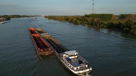 Luftaufnahme-Des-Frachtschiffs-Mit-Schüttgut-In-Lastkähnen,-Die-Sich-Langsam-Auf-Dem-Fluss-Bewegen