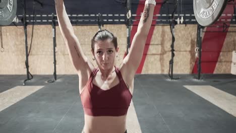 mujer levantando pesas en un gimnasio