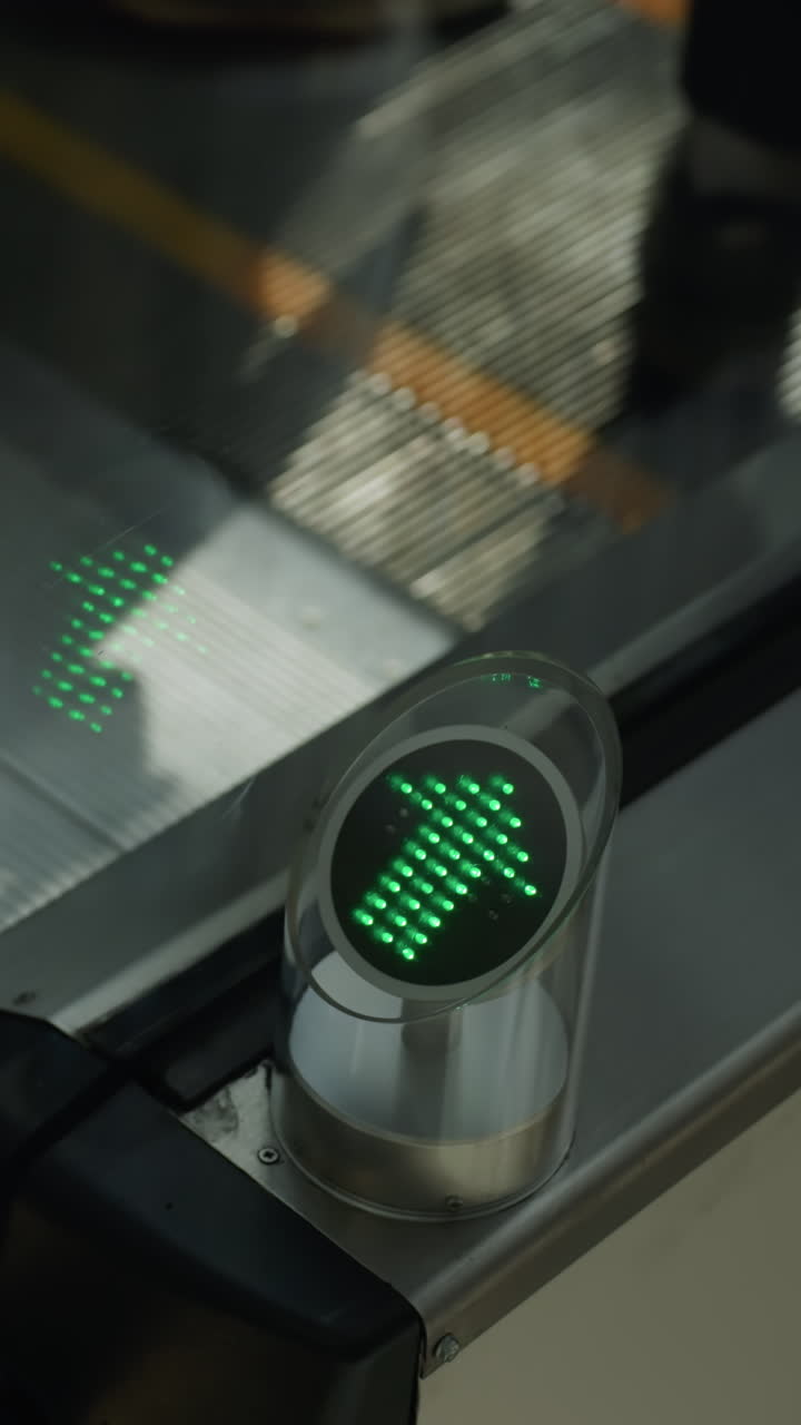 un primer plano que captura el movimiento de las botas negras en una escalera mecánica que desciende. el enfoque está en los escalones mecánicos y la luz direccional verde