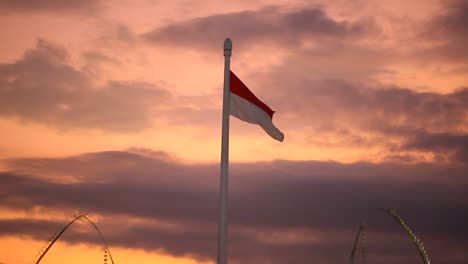 bandera indonesia ondeando en un poste alto contra un espectacular cielo nocturno
