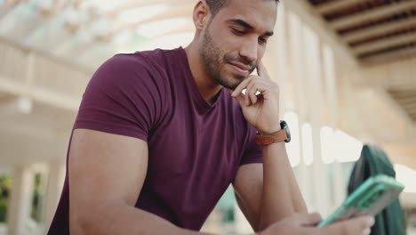 young man texting on smartphone and sitting outdoors.