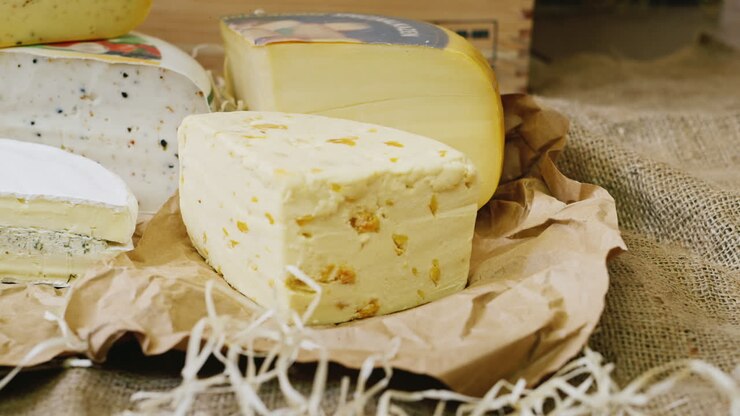 Showcase Of The Cheese Shop Appetizing Pieces Of Cheese Of Different Varieties