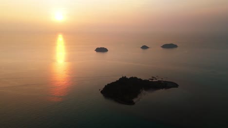 aerial descend to koh chang tropical islands at sunset, golden light over the calm ocean