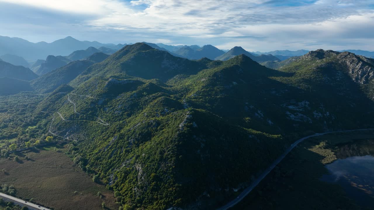 호수 와 휘어지는 도로 가 있는 산악 풍경