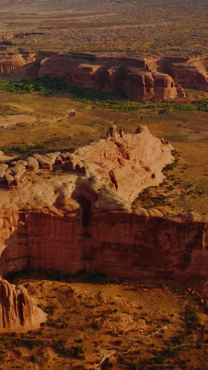 Arches canyons in Utah, USA. Amazing landscape of huge rocks in the rays of bright sun. Aerial view. Vertical video