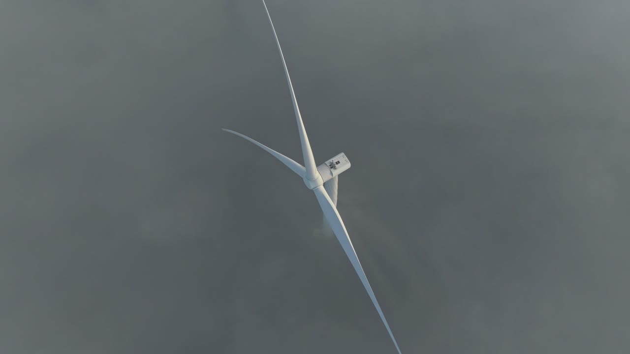 Wind turbine rotating generating electricity in foggy weather