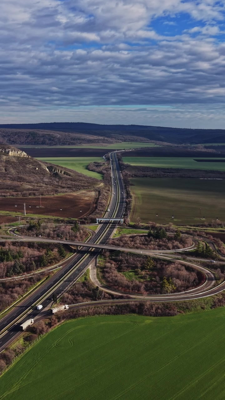 Vogelperspektive von Feldern und Autobahnen nahe einem Hügel auf dem Land