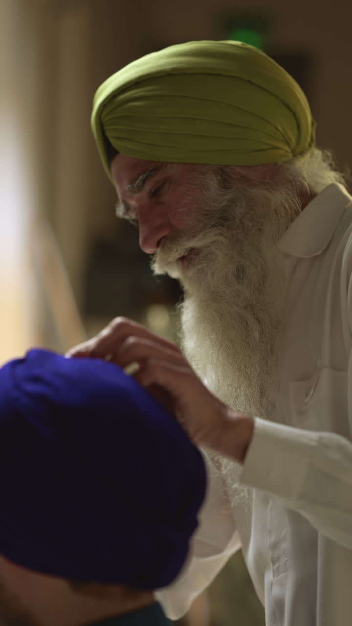Sikh man adjusting the turban of another man