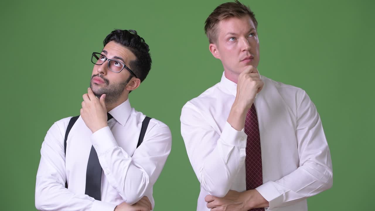 dos jóvenes empresarios multiétnicos trabajando juntos contra un fondo verde