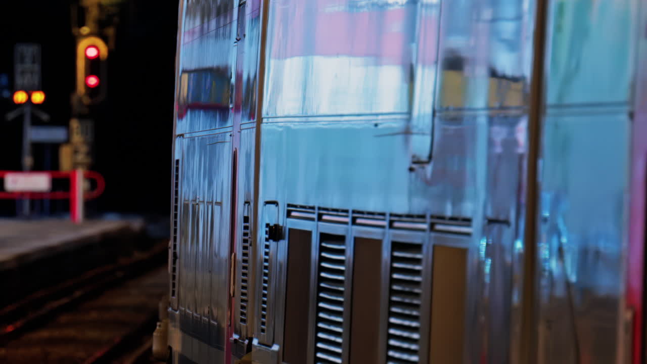 Close up of a train moving on the rails near a station in the south of France at night