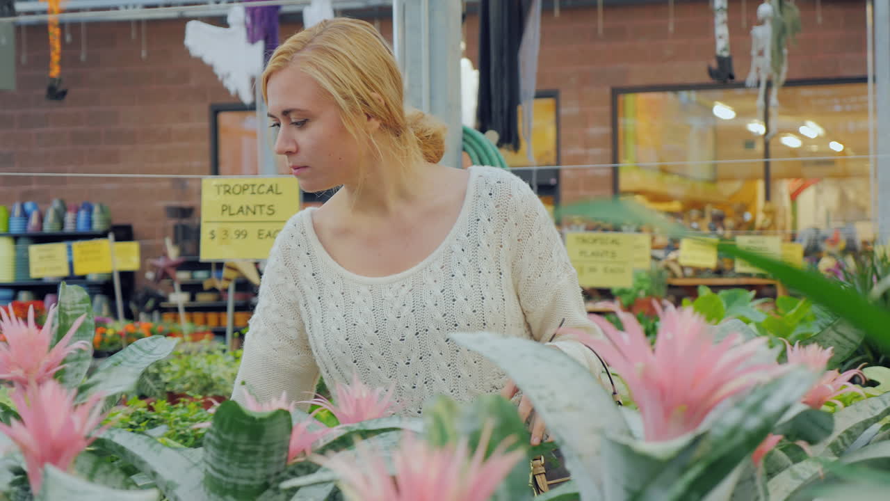 молодая кавказская женщина выбирает цветы для озеленения в питомнике 2