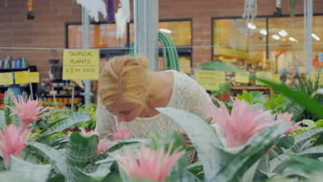 young caucasian woman chooses flowers for landscaping in the nursery 2