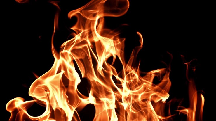 Primo piano di vere fiamme di fuoco che bruciano su sfondo nero