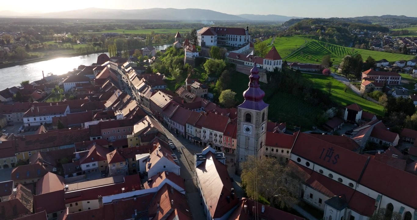 Mozzafiato riprese aeree di Ptuj, la città più antica della Slovenia, con i suoi storici edifici dai tetti rossi, il fiume Drava e il maestoso Castello di Ptuj sulla collina