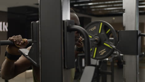 man performing barbell back squat in gym