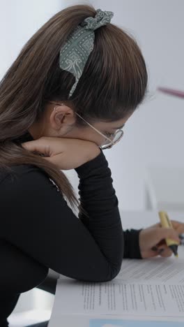 woman studying and highlighting documents