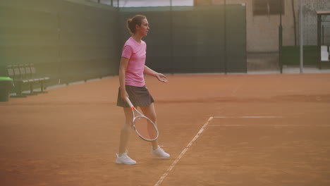 a tired brunette female tennis player walks along the tennis court recuperating and concentrating. break in a tennis match. tennis player after the match on the map at sunset in slow motion.