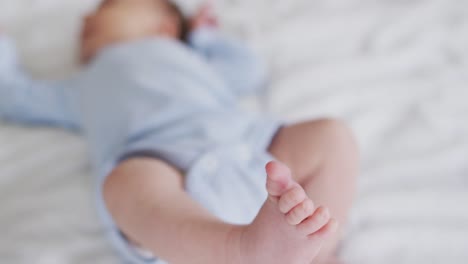 video of feet of caucasian newborn baby lying on bed