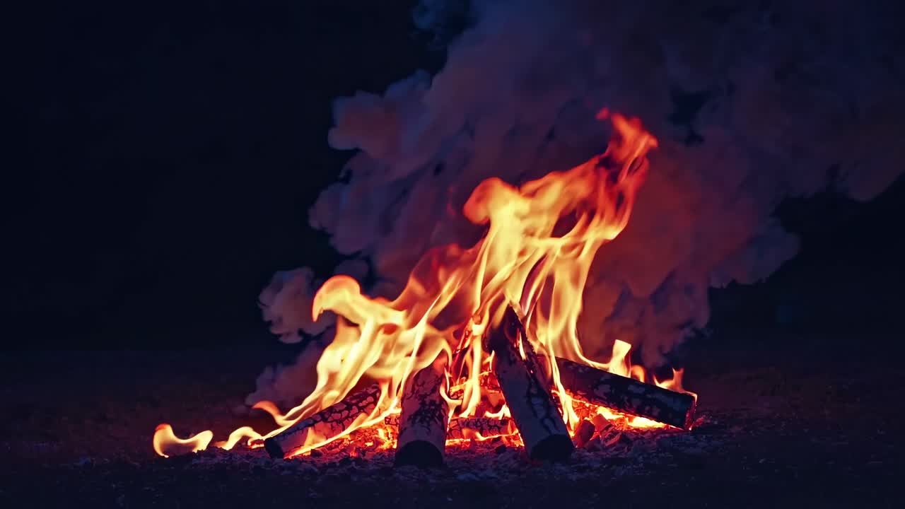 Un video ipnotico di un falò ripreso dal basso, che cattura fiamme vivaci e fumo.
