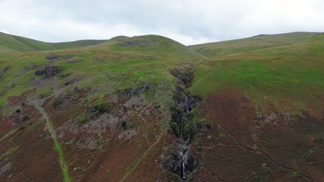 Slow-zoom-into-waterfall-on-bleak-empty-hillside