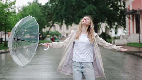 carefree young blonde woman lets the refreshing spring rain fall down on her