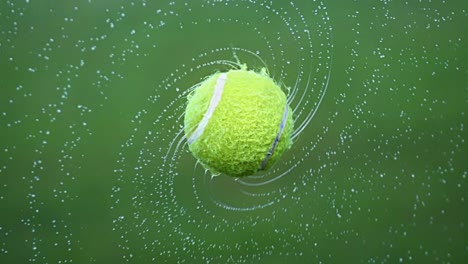 wet tennis ball with flying water droplets background