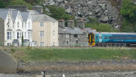 Train-passing-at-Barmouth-Beach,-North-wales