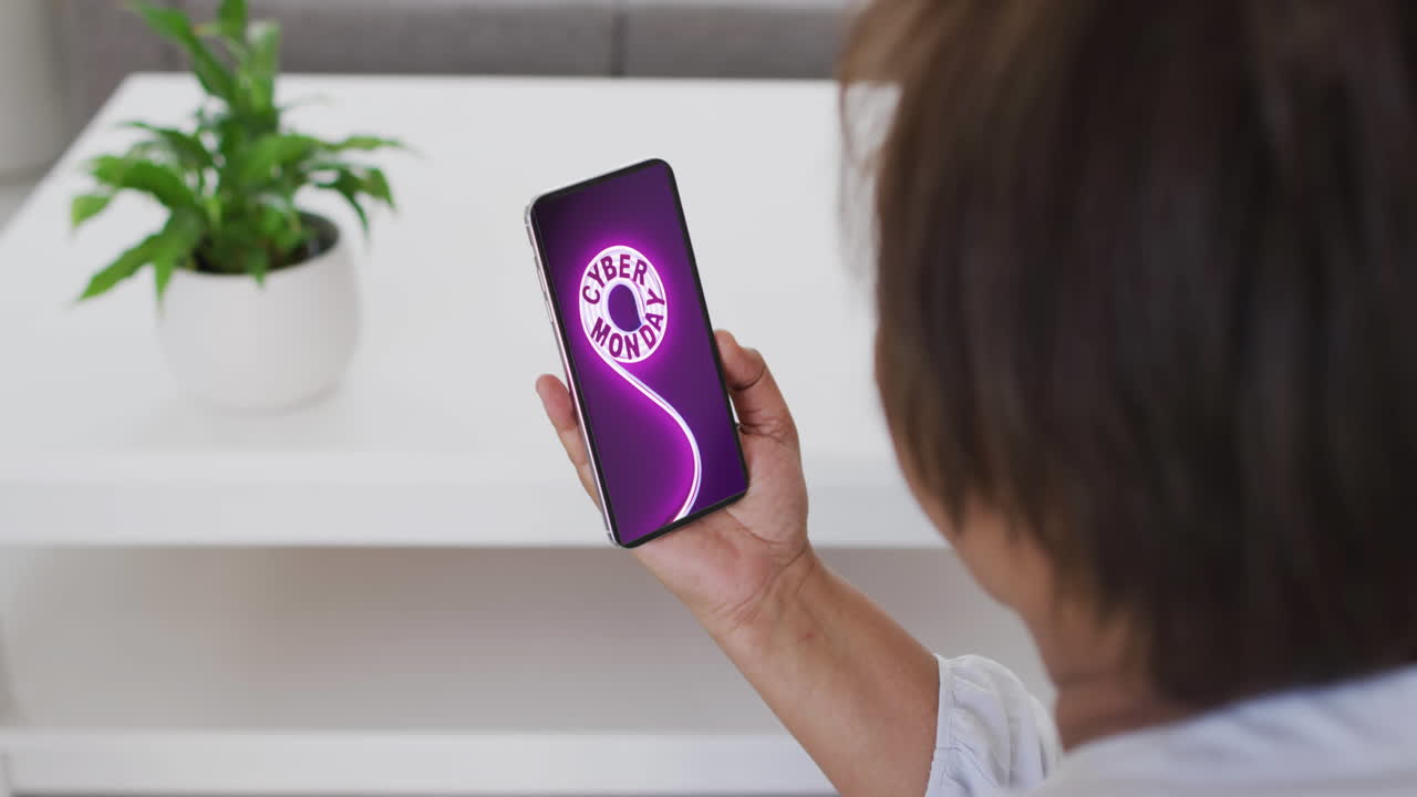 mujer biracial usando teléfono inteligente en casa para comprar en línea, cámara lenta