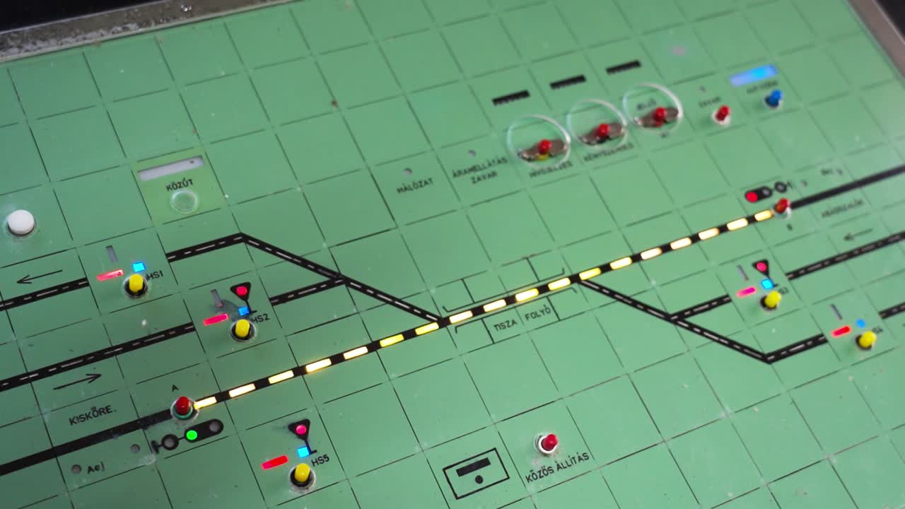 A railway control board with illuminated tracks, signals, and switches for train traffic management