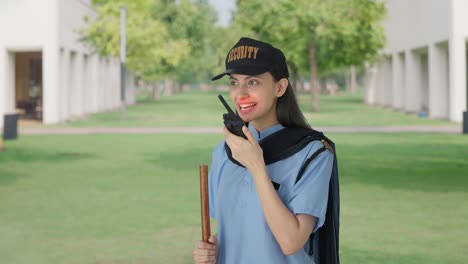 happy indian female security guard talking through walkie talkie