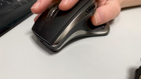 male hand uses a computer mouse in an office in close-up