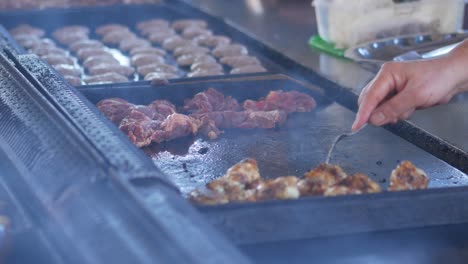 chef grilling meat on flat top grill