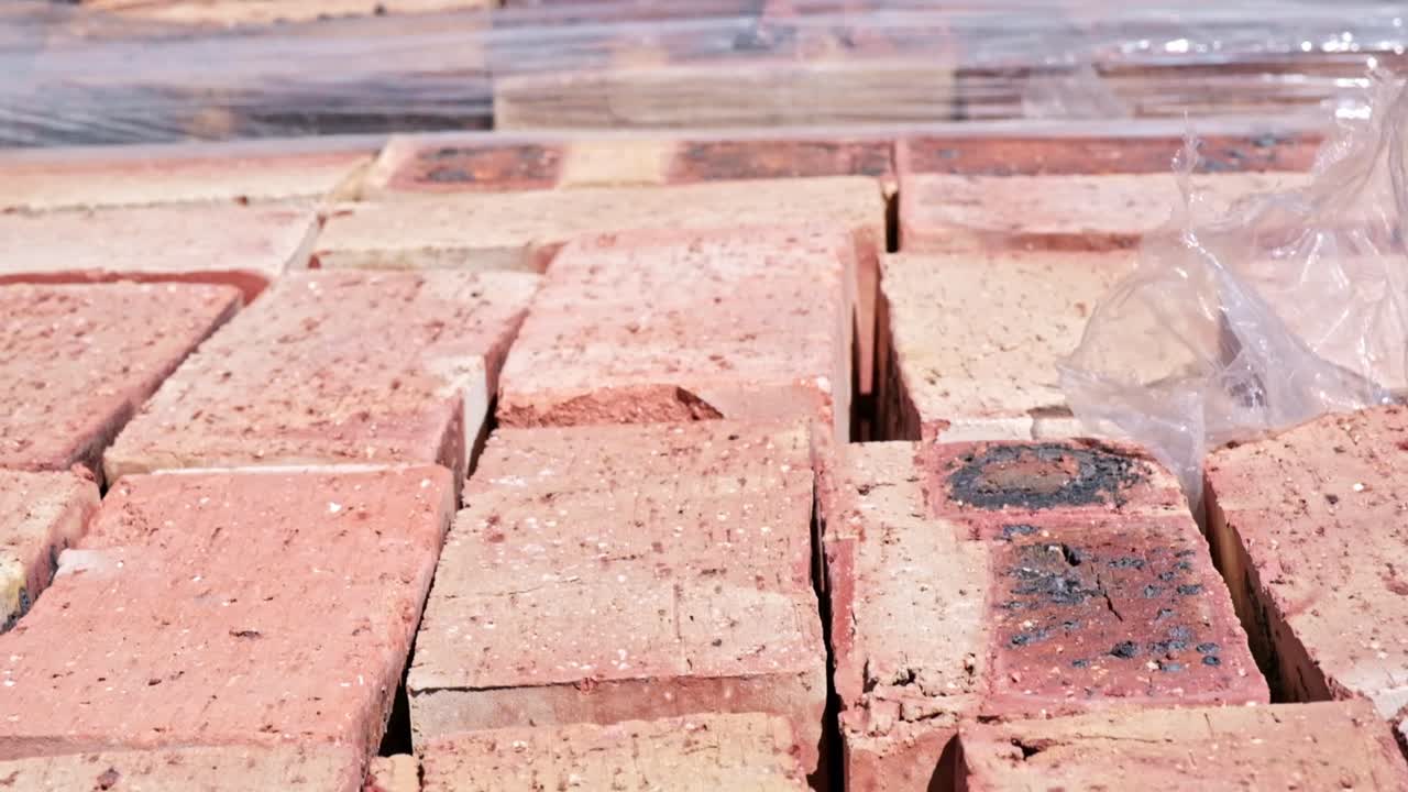 Neatly packed clay bricks ready for the construction of a house
